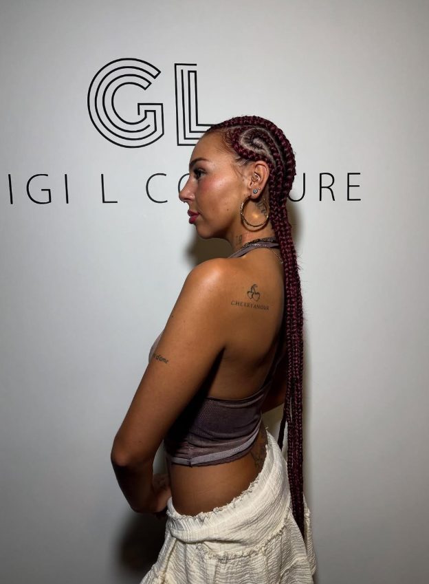 Cornrows bordeaux longs devant le mur GiGi L
